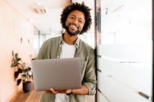 Young, smiling small business owner standing in his office.