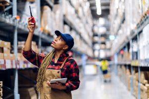 Female African American warehouse manager taking inventory.