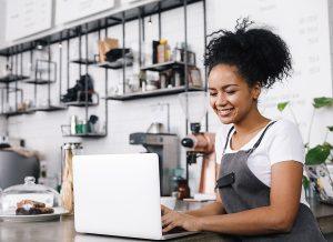 Young woman shopping for BOP insurance in her cafe.